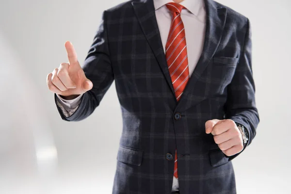 Ausgeschnittener Blick auf jungen Geschäftsmann, der auf Grau zeigt — Stockfoto