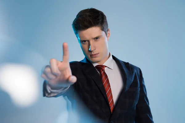 Selektiver Fokus des selbstbewussten Geschäftsmannes, der etwas mit dem Finger auf Blau berührt — Stockfoto