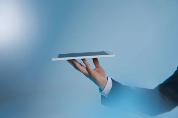 Selective focus of man hand with digital tablet on blue — Stock Photo