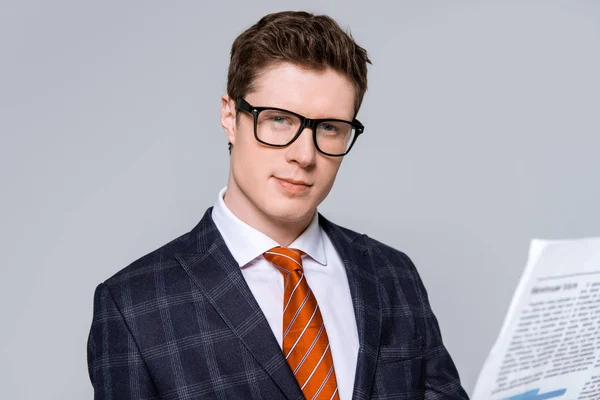 Stylish handsome businessman with newspaper isolated on grey — Stock Photo