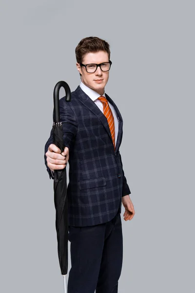 Студийный снимок стильного бизнесмена, позирующего с зонтиком, изолированным на сером — стоковое фото