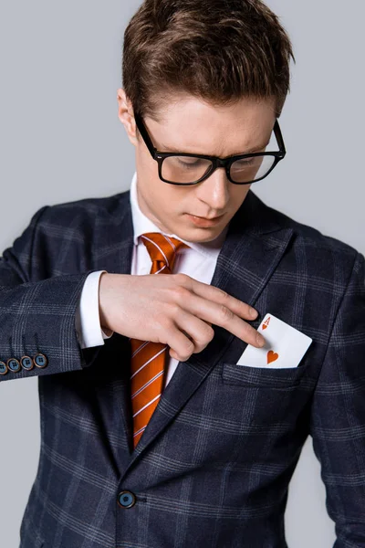 Guapo elegante hombre de negocios tomando as de bolsillo aislado en gris - foto de stock