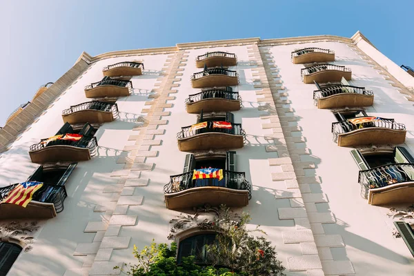 Casa bianca con balconi con bandiere nazionali, barcellona, Spagna — Foto stock