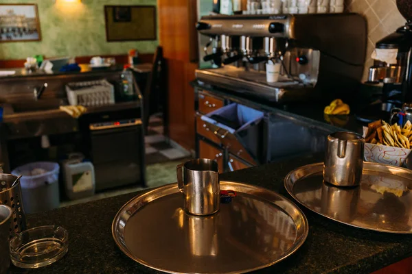 Enfoque selectivo de bandejas redondas metálicas y tazas en el mostrador de bar en la cafetería, barcelona, España - foto de stock