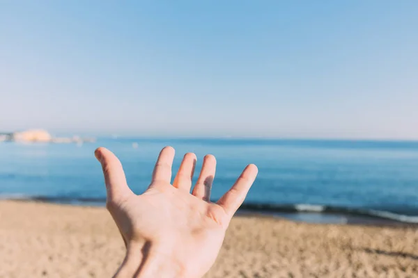 Male hand on calm blue sea background, barcelona, spain — Stock Photo