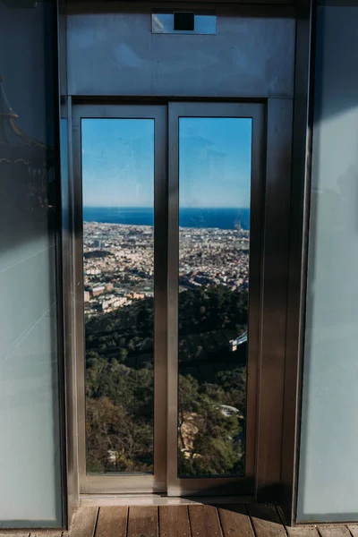 Finestra con vista panoramica della città a piedi di verdi colline, Barcellona, Spagna — Foto stock