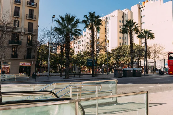 БАРСЕЛОНА, Испания - 28 ДЕКАБРЯ 2018 года: широкая улица с многоэтажным зданием и высокими зелеными пальмами — стоковое фото