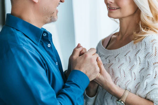 Ausgeschnittene Ansicht eines fröhlichen Paares, das lächelnd Händchen hält — Stock Photo