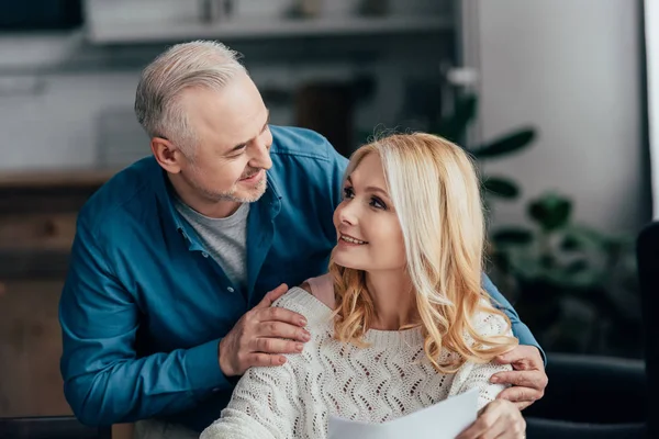 Happy husband embracing cheerful wife at home — Stock Photo