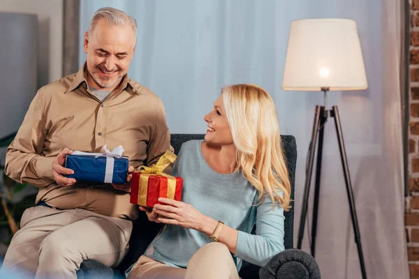 Приваблива дружина і посміхається біля чоловіка тримає подарункові коробки в руках — Stock Photo