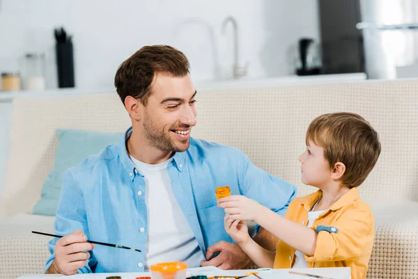 Handsome father and adorable preschooler son drawing at home — Stock Photo
