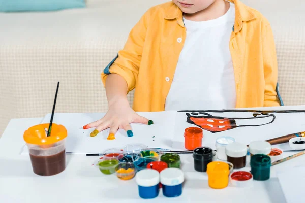 Vista recortada del niño en edad preescolar durante la pintura en casa - foto de stock