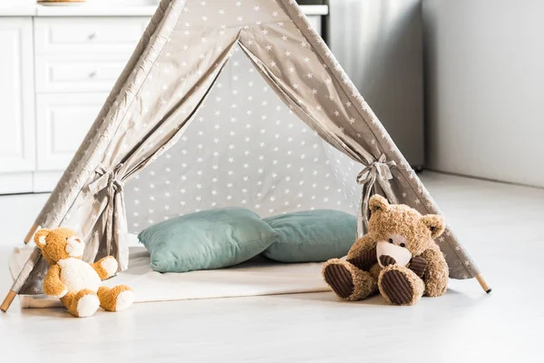 Modern interior design of nursery room with baby wigwam and teddy bears — Stock Photo