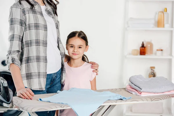 Mutter und Tochter nahe Bügelbrett in Waschküche — Stockfoto