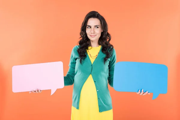 Pensive curly pregnant woman holding speech bubbles on orange background — Stock Photo