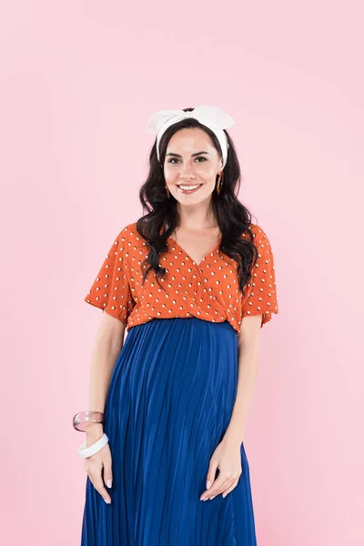 Attractive curly pregnant woman in blue skirt isolated on pink — Stock Photo