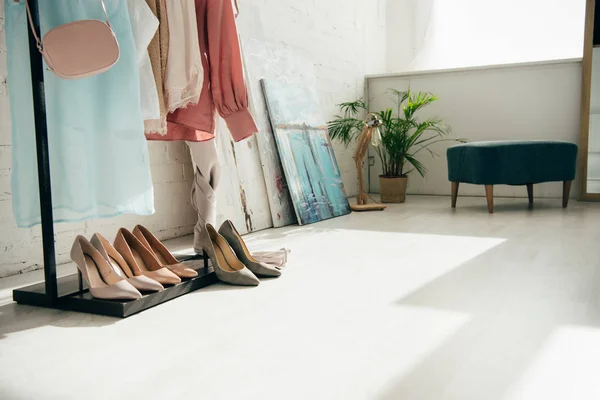 Fashionable clothes near high heels and white brick wall — Stock Photo