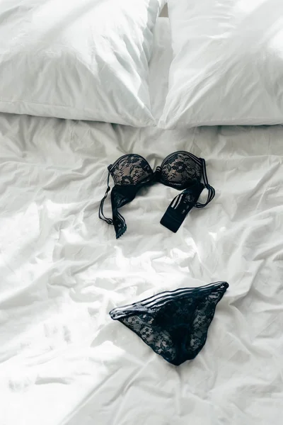 Sexy black lace bra and panties on bed — Stock Photo