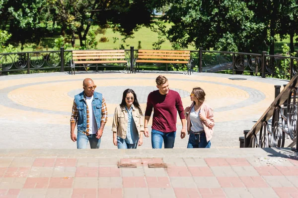 Gruppo multiculturale di amici sorridenti nel parco — Foto stock