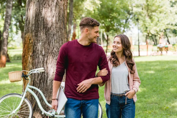 Fröhlicher Mann, der das schöne Mädchen mit der Hand in der Tasche ansieht — Stockfoto