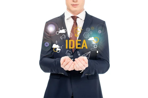 Cropped view of businessman in suit with outstretched hands and idea lettering and icons above isolated on white — Stock Photo