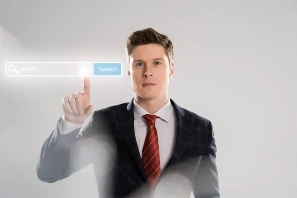 Confident businessman in suit pointing with finger at search bar illustration in front — Stock Photo
