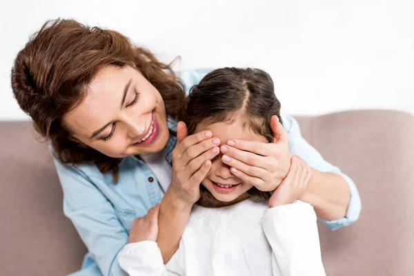 Sonriente madre jugando con su hijita aislada en blanco - foto de stock