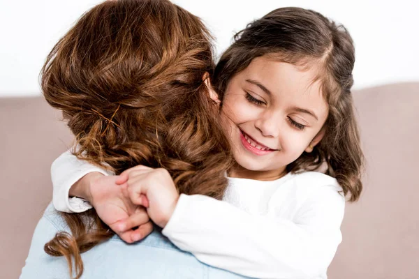 Alegre sonriente niño preescolar abrazando madre aislada en blanco - foto de stock
