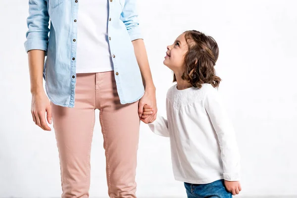 Частковий вигляд жінки в блакитній сорочці тримає руки з дочкою на білому — стокове фото