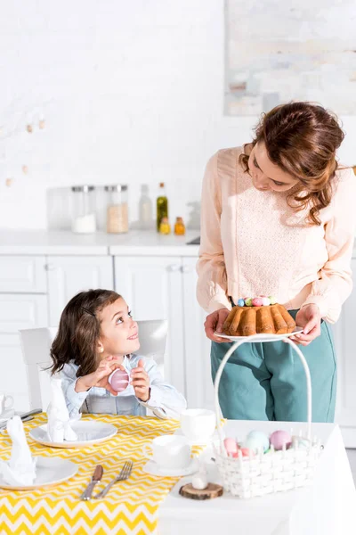 Mother and daughter looking at each other while serving table for easter — Stock Photo