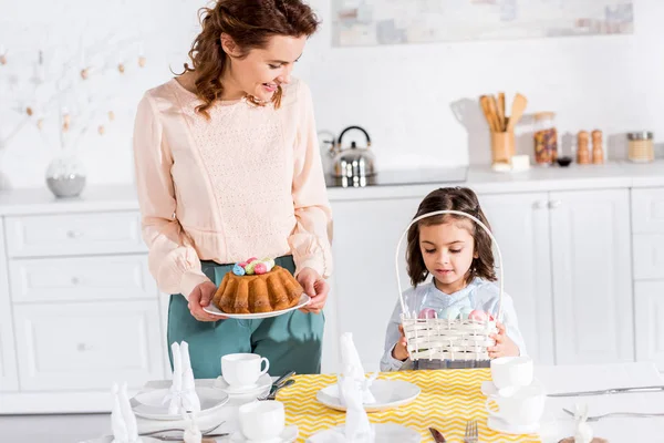 Mother and daughter serving table for easter in kitchen — Stock Photo