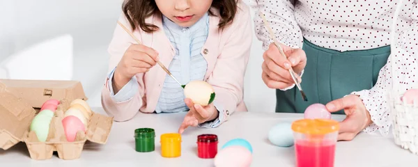 Foto panorámica de madre e hija pintando huevos de Pascua - foto de stock