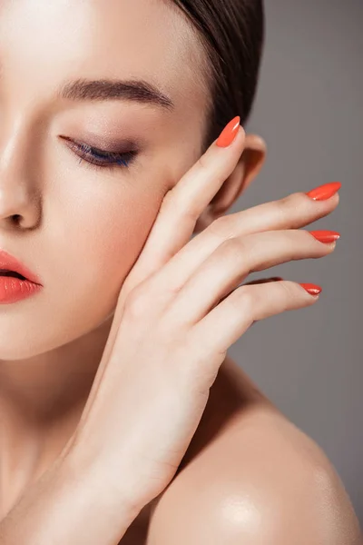 Beautiful stylish girl touching face and posing isolated on grey — Stock Photo