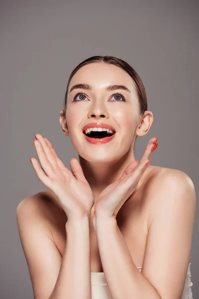 Bela menina sorridente gesticulando com as mãos e posando isolado no cinza — Fotografia de Stock