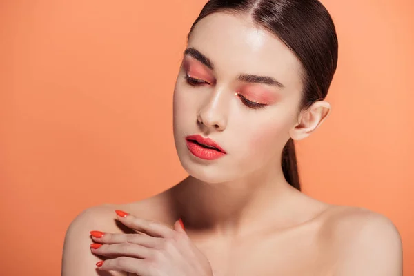 Beautiful stylish young woman posing isolated on coral with copy space — Stock Photo