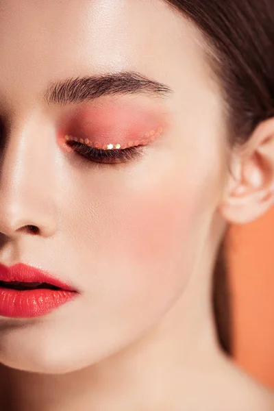 Selective focus of beautiful stylish young woman posing isolated on coral — Stock Photo