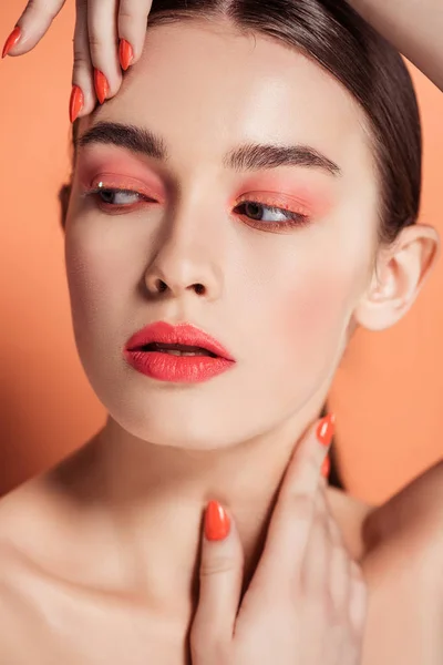 Bella elegante giovane donna in posa su sfondo corallo — Foto stock