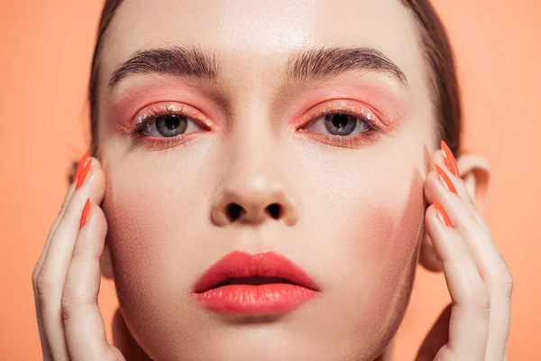 Beautiful stylish young woman looking at camera and posing isolated on coral — Stock Photo