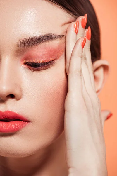 Beautiful stylish young woman with glitter makeup isolated on coral — Stock Photo