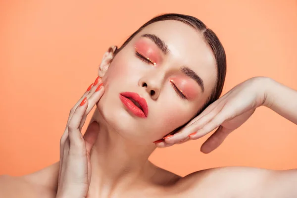 Belle jeune femme élégante avec maquillage paillettes posant isolé sur le corail — Photo de stock