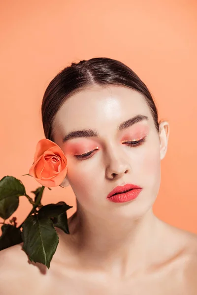 Bella ragazza elegante con fiore di rosa posa isolata sul corallo — Foto stock