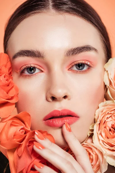 Bela menina da moda posando com flores de rosas isoladas em coral — Fotografia de Stock