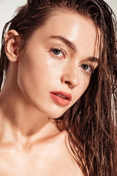 Beautiful young woman with coral lips and wet hair looking at camera — Stock Photo