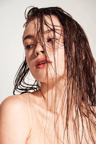 Schöne nackte junge Frau mit korallenen Lippen und nassen Haaren posiert isoliert auf grau — Stockfoto