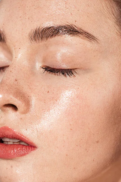Close up de mulher jovem com os olhos fechados, lábios de coral e pele molhada — Fotografia de Stock