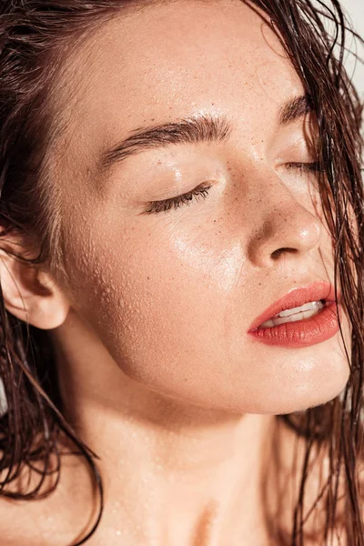 Schöne junge Frau mit korallenen Lippen, geschlossenen Augen und nassen Haaren — Stockfoto
