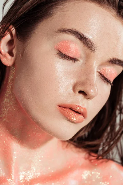 Beautiful stylish girl covered in coral glitter posing with eyes closed — Stock Photo