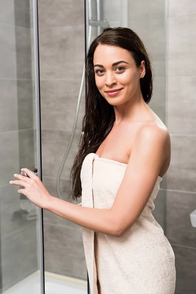 Mulher bonita feliz sorrindo enquanto estava perto da cabine do chuveiro no banheiro — Fotografia de Stock