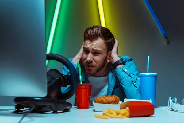 Handsome and upset man touching his head and looking at computer monitor — Stock Photo