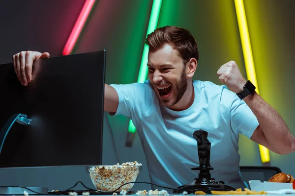 Schöner und glücklicher Mann hält Computermonitor und zeigt Ja-Geste — Stockfoto